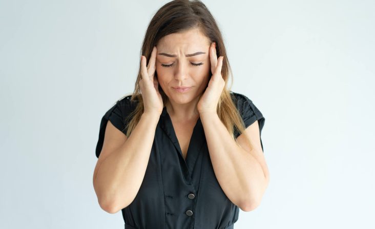 Mujer sufriendo de dolores orofaciales como dolor de cabeza
